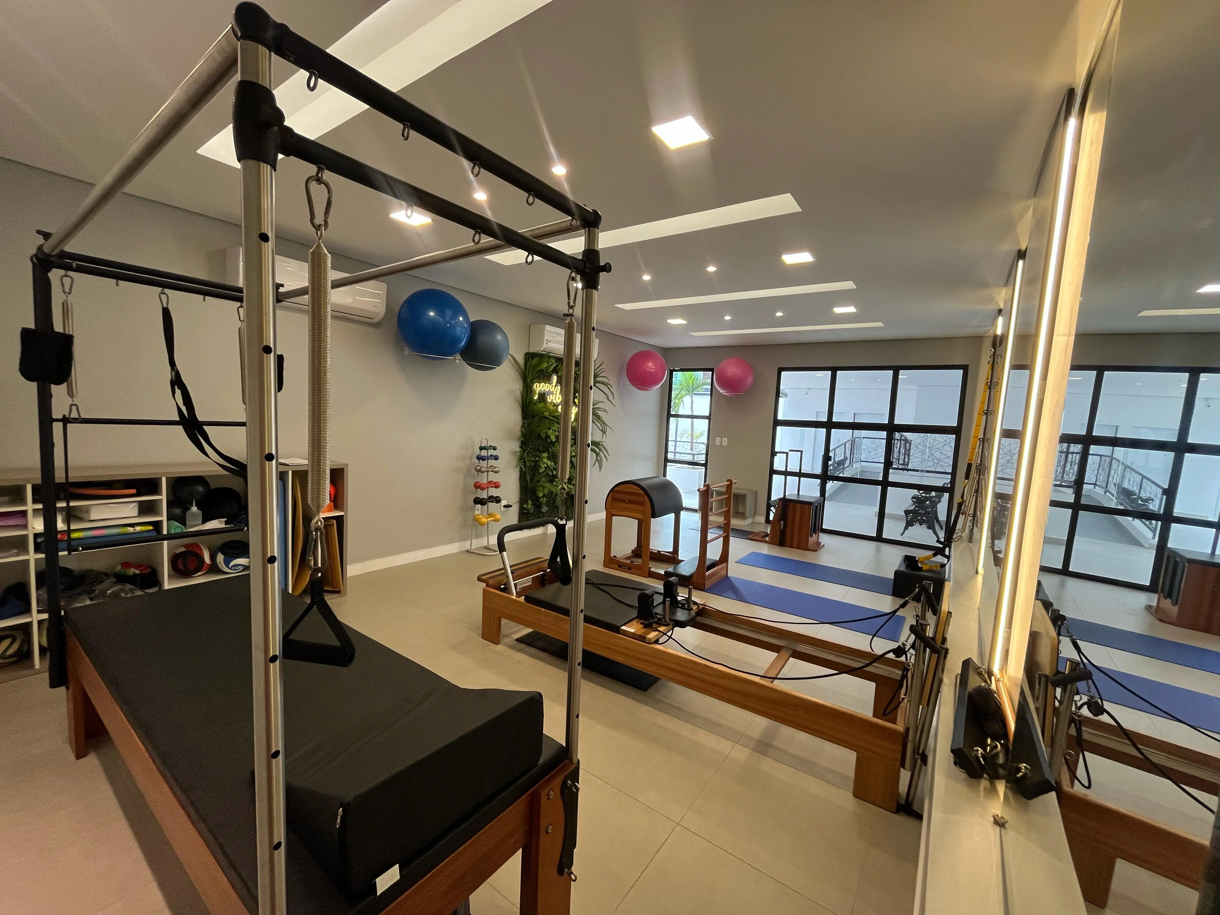 Aparelhos de Pilates e amplo espelho no studio da Clínica Conceber